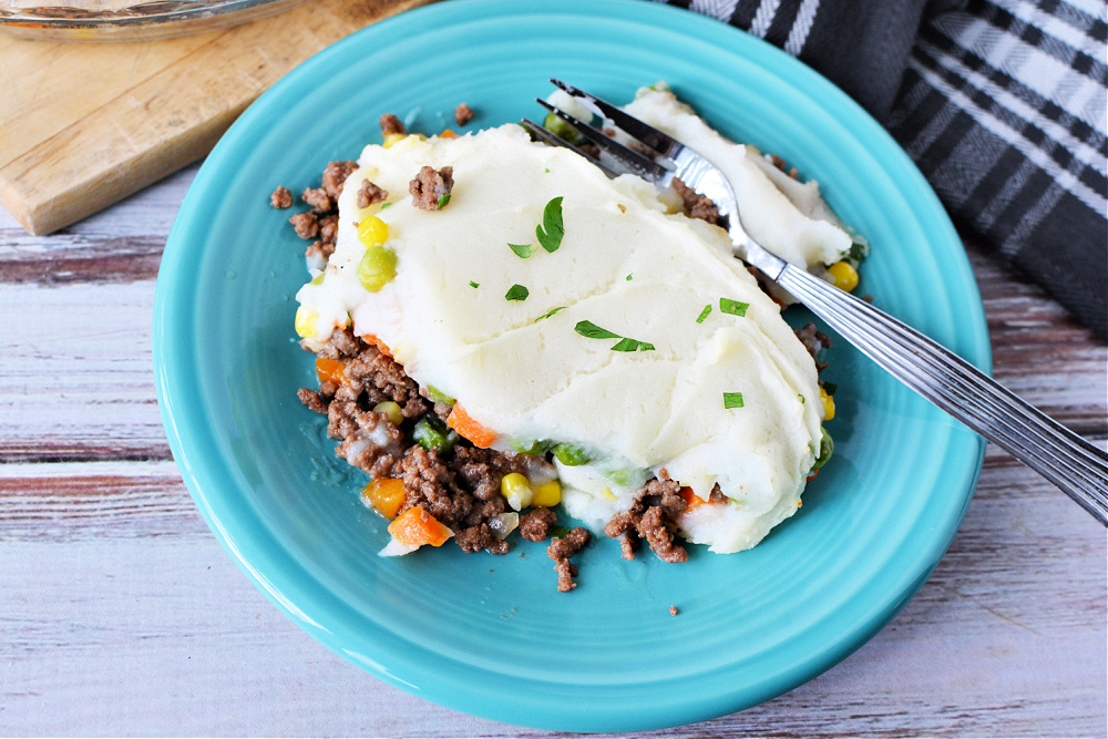 mashed potatoes on top of ground beef and mixed vegetables