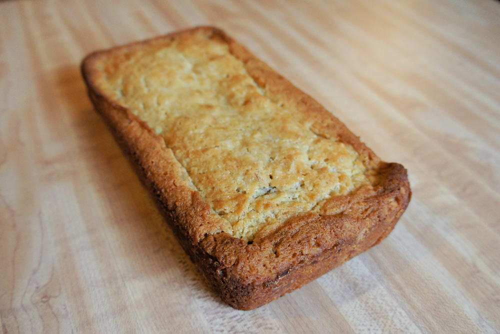 Loaf of Coconut Banana Bread on a wooden cutting board