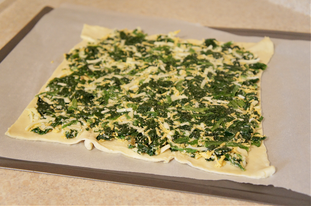puff pastry rolled out and topped with cheese and spinach
