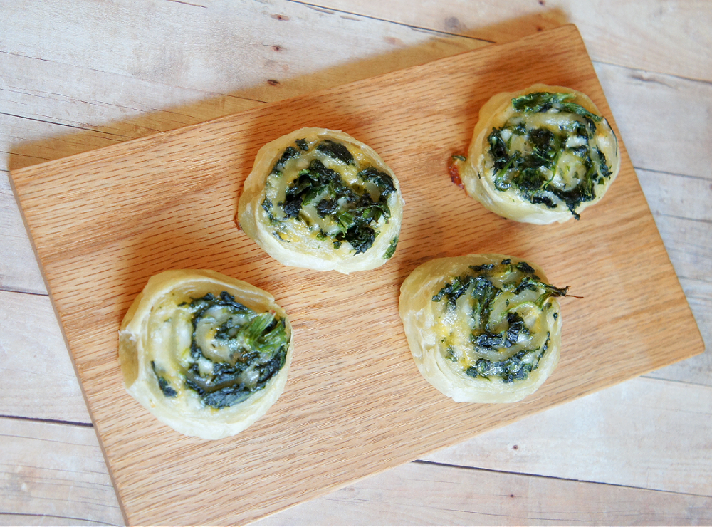 pinwheels filled with spinach and cheese on a wooden cutting board