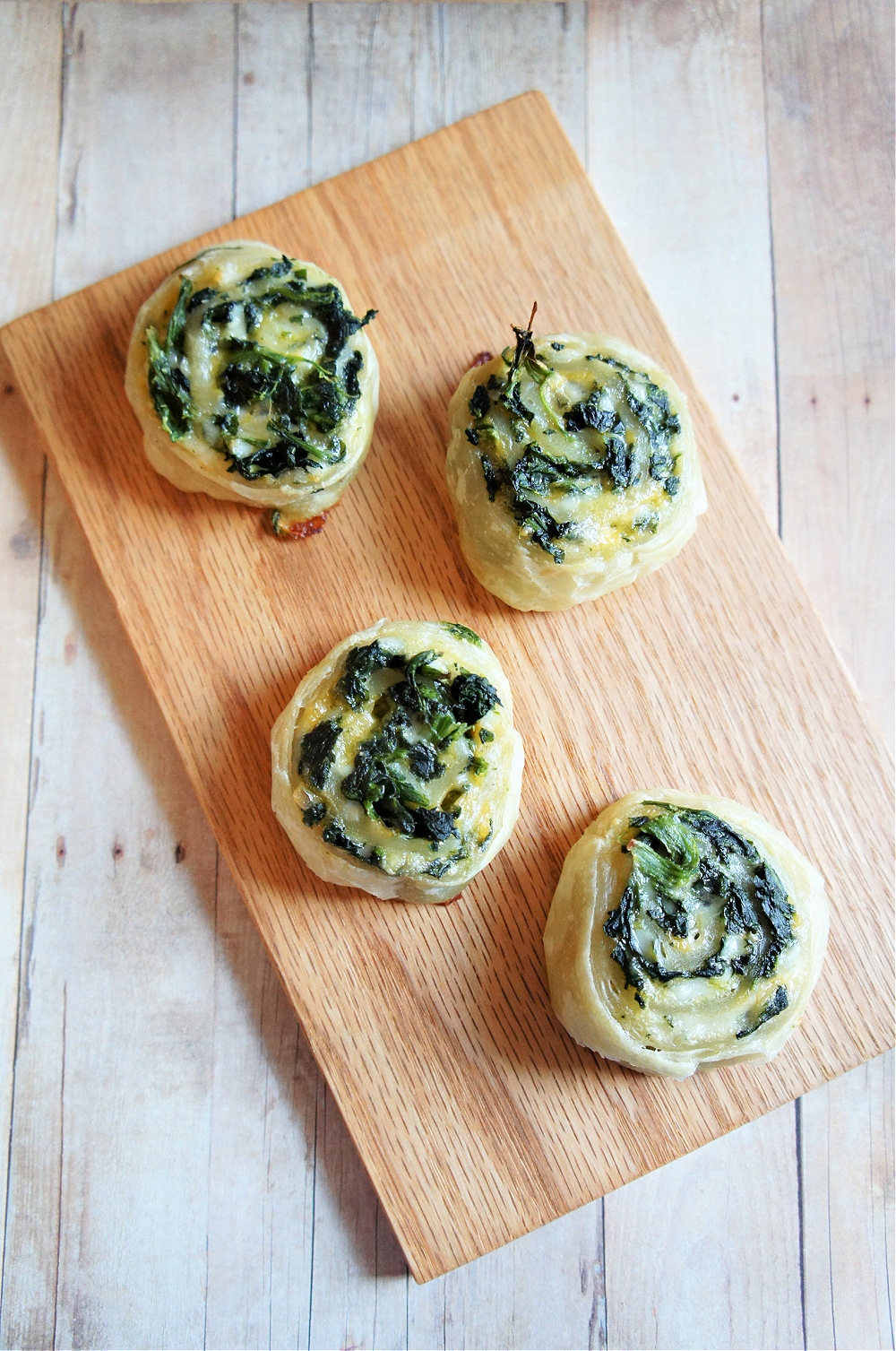 pinwheels filled with spinach and cheese on a wooden cutting board