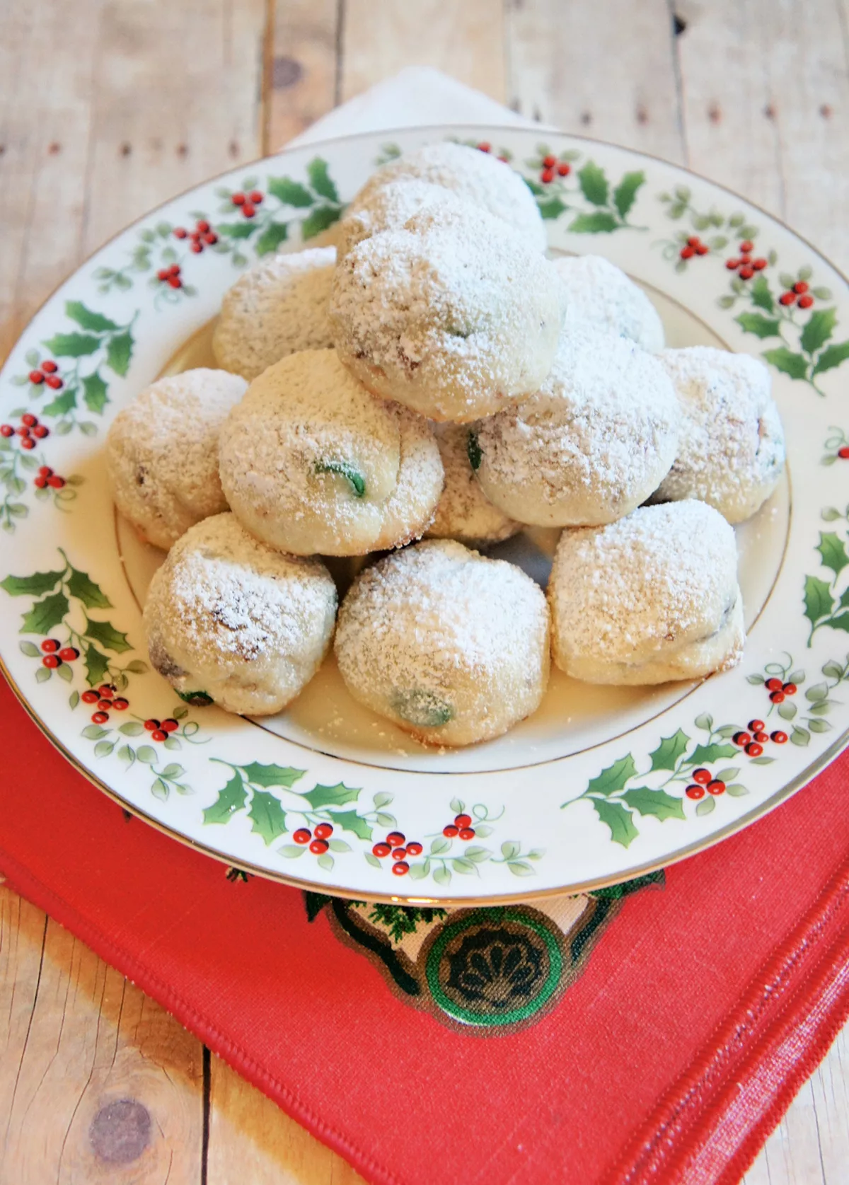 Easy Homemade Christmas Snowball Cookies covered in powdered sugar on a plate