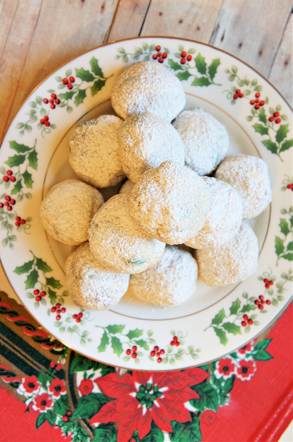 cookies covered in powdered sugar on a christmas plate
