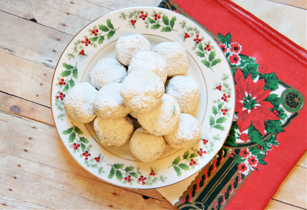 cookies covered in powdered sugar on a christmas plate