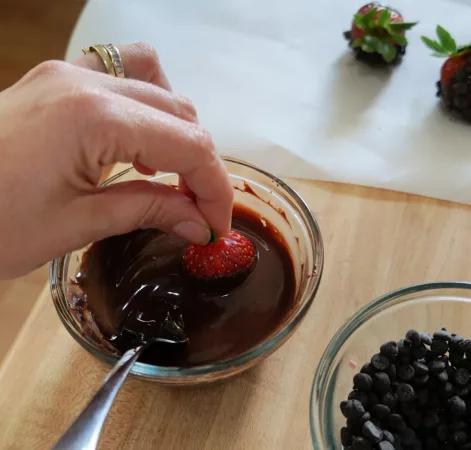 Dipping a strawberry into chocolate