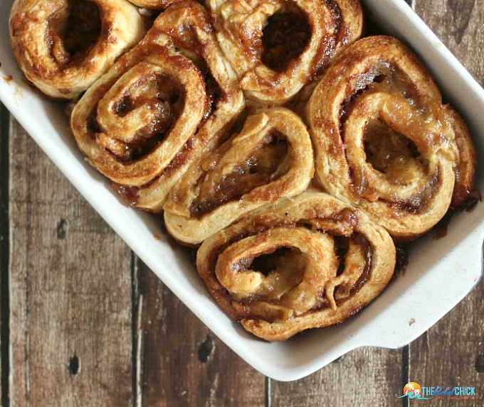 rolls with cinnamon sugar and apples in a baking dish