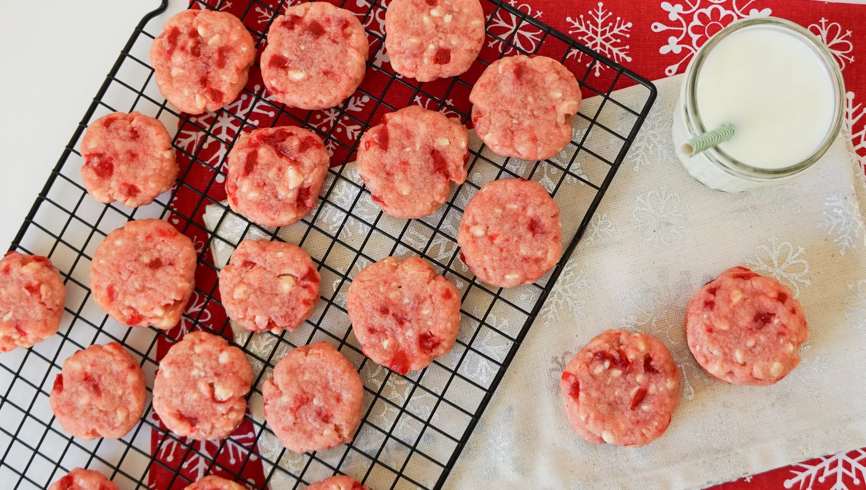 Cherry Shortbread Cookies on a cooling rack with a glass of milk