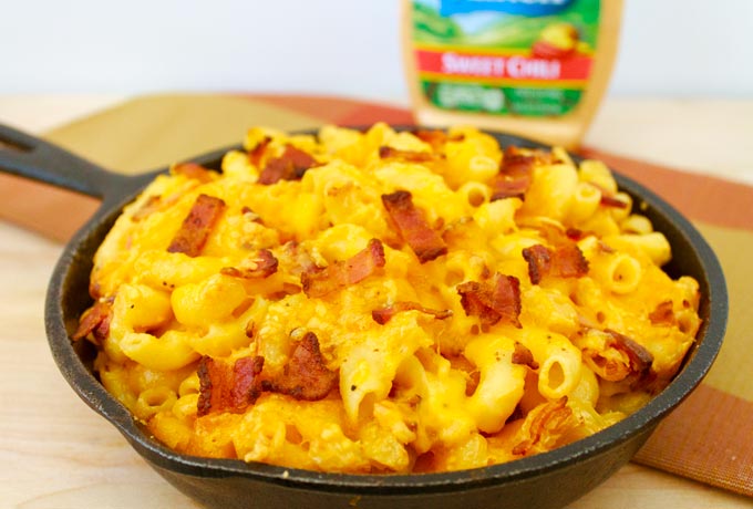 overhead shot of cast iron pan filled with  macaroni and cheese and pieces of bacon