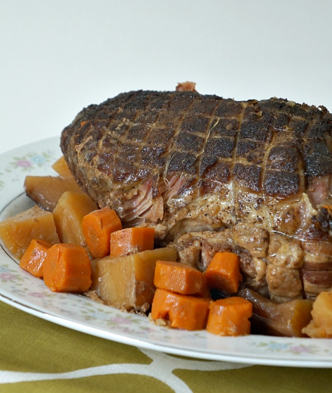 pork roast on a bed of carrots and potatoes