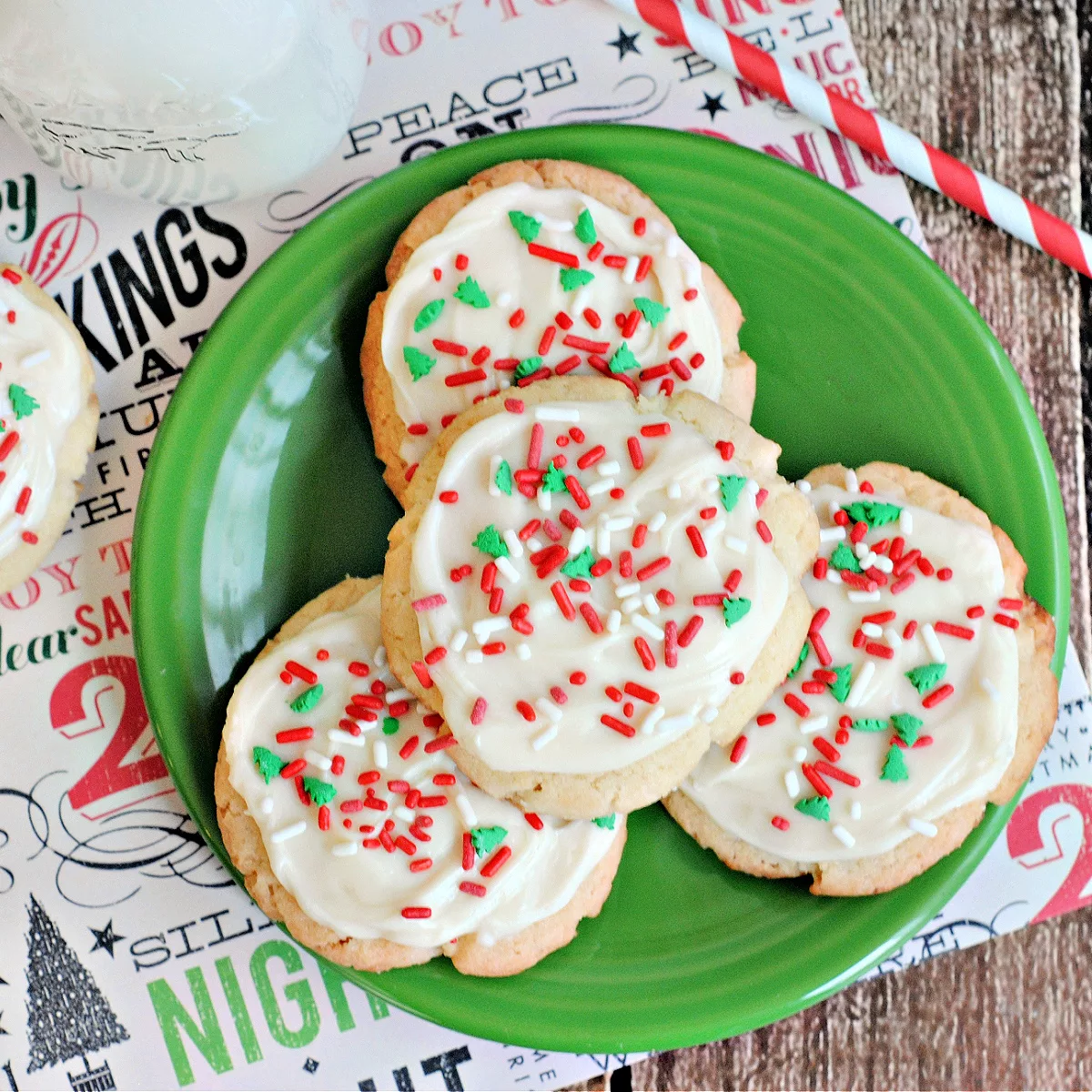 Cake Mix Christmas Sugar Cookies frosted with vanilla icing and covered in red and green sprinkles on a plate