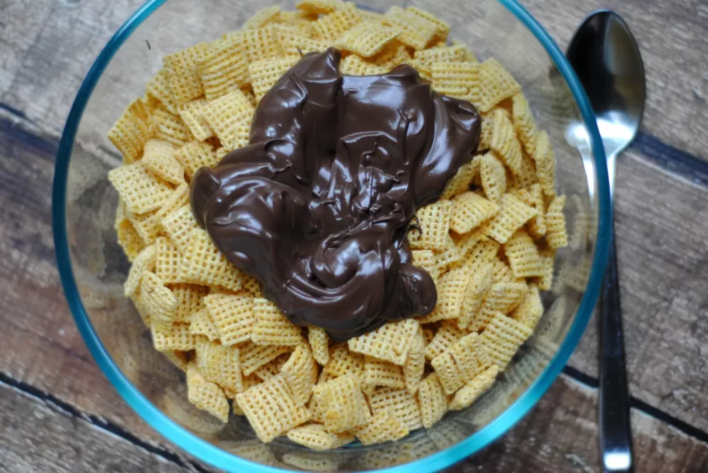 melted chocolate on top of cereal in a bowl