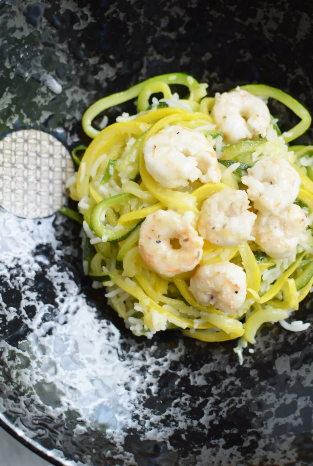 Shrimp and spiralized zucchini on a black plate