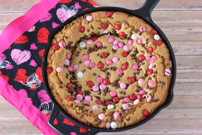 M&MS and chocolate chip cookie made in a cast iron skillet on the stovetop