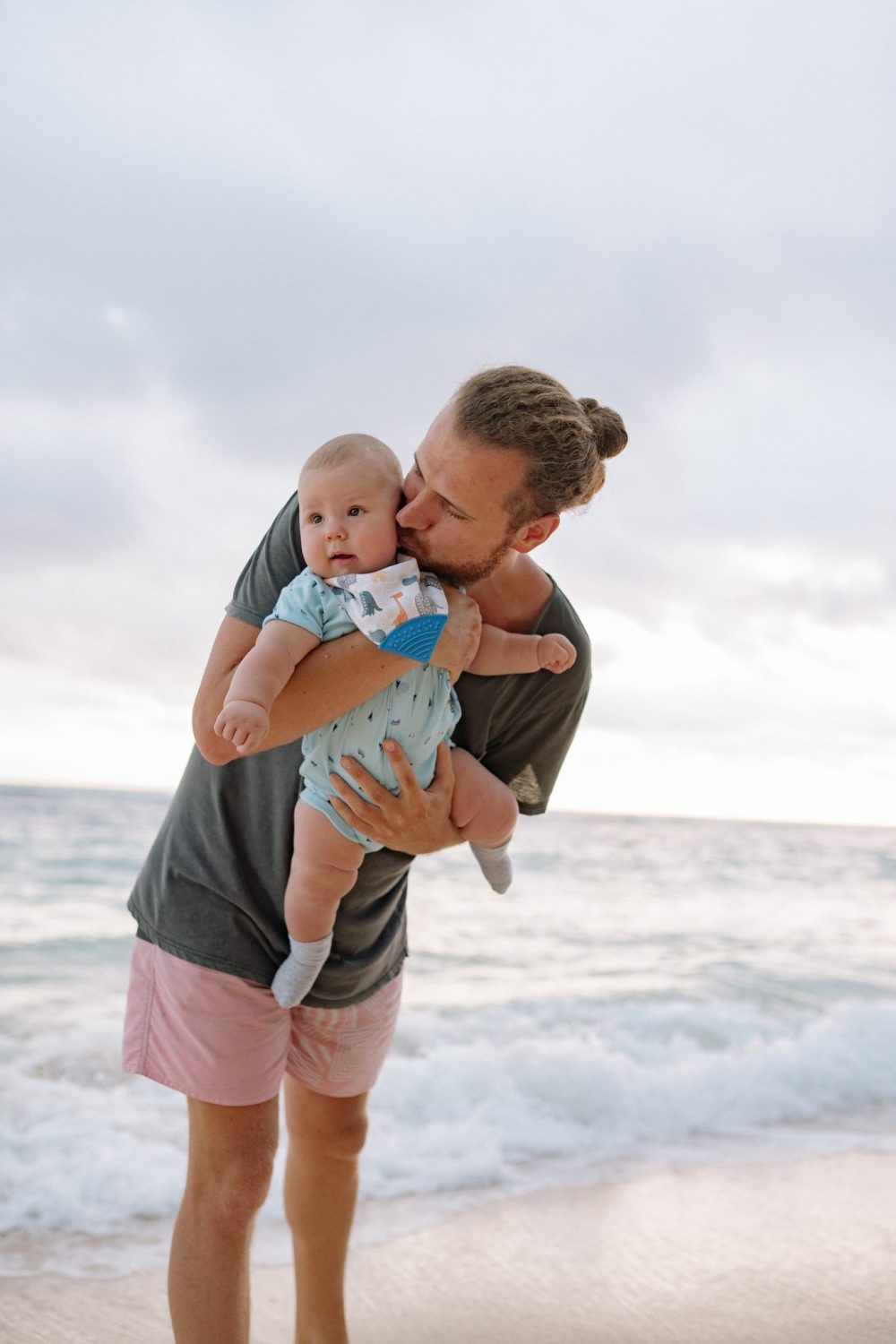 Dad and baby playing in the surf on a beach