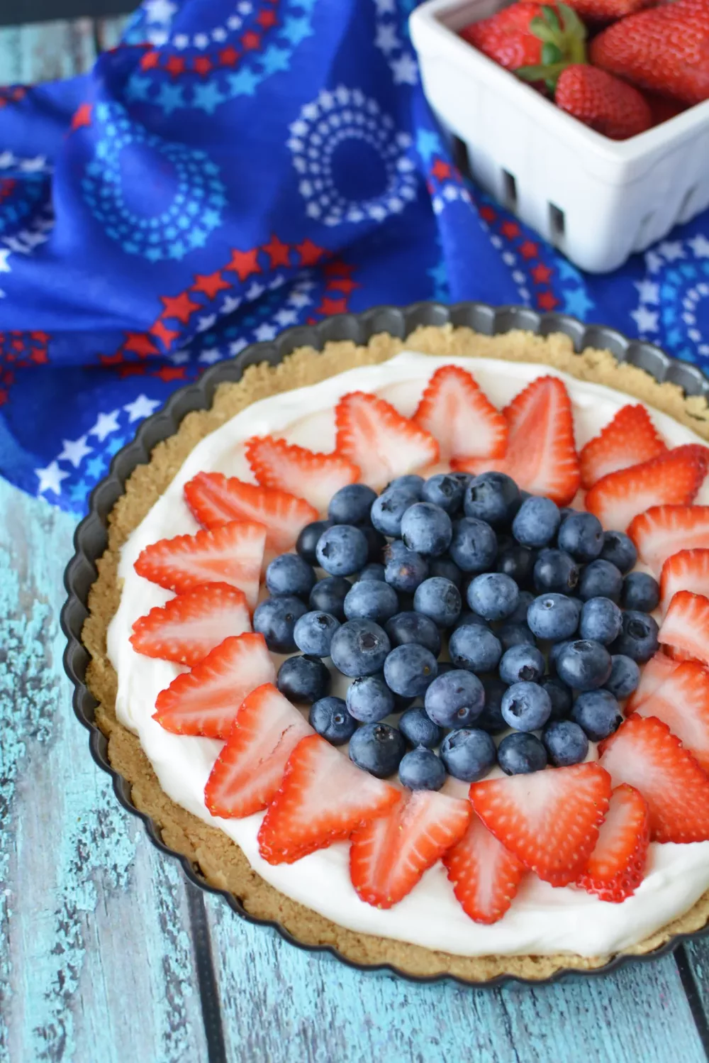 tart filled with cream cheese filling and decorated with blueberries and strawberries