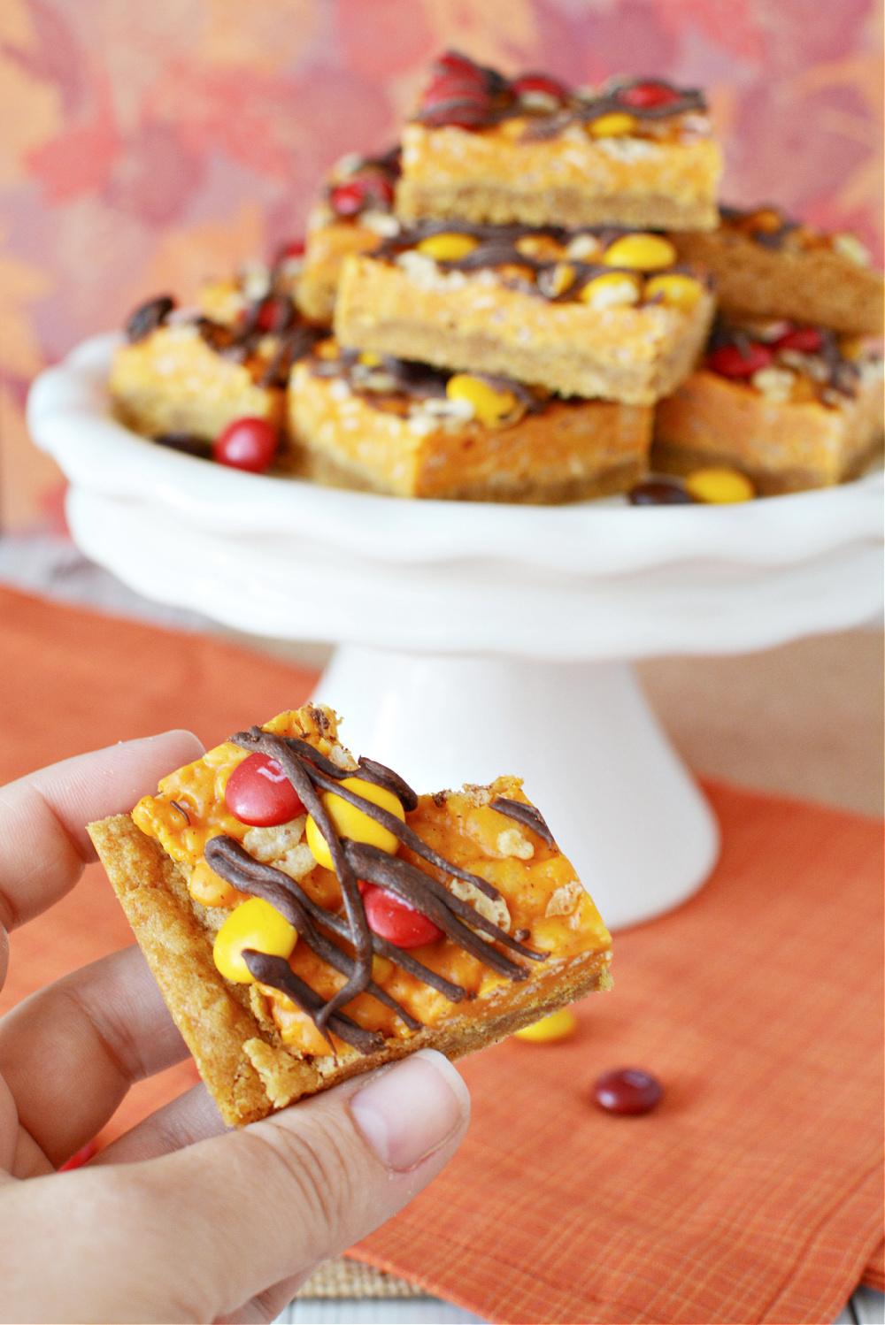 Pumpkin bars filled with spice, chocolate candies, and drizzled with chocolate