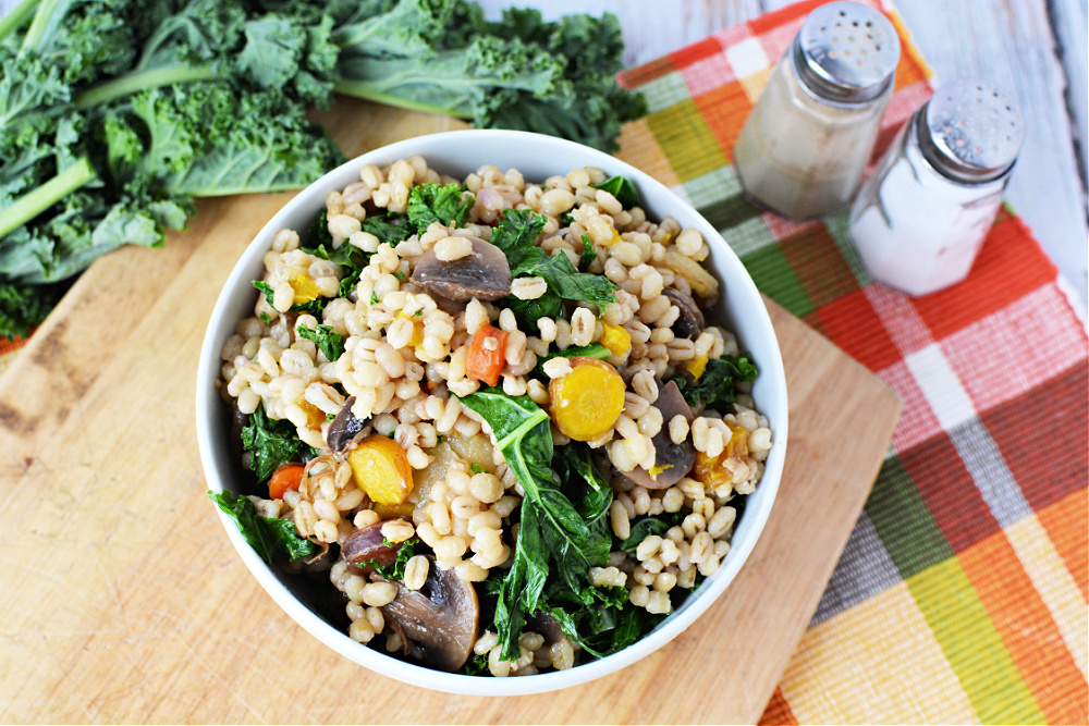 bowl full of risotto with kale, carrots and barley