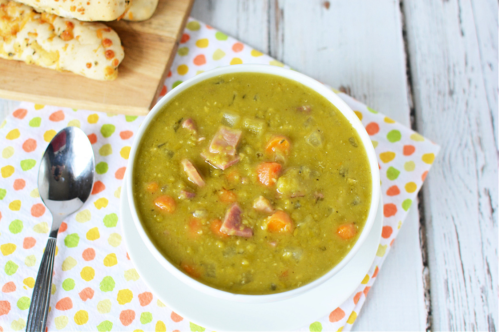 a bowl of split pea soup with ham chunks.