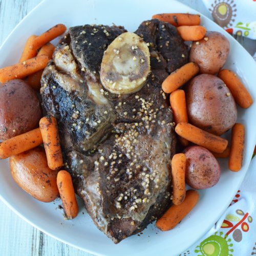 heart shaped roast beef surrounded by baby red potatoes and carrots