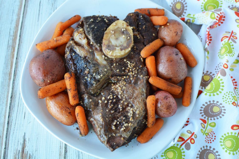 heart shaped roast beef surrounded by baby red potatoes and carrots