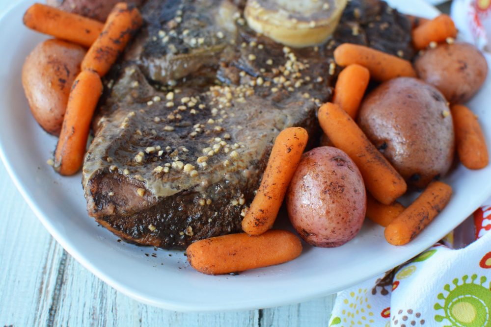 roast beef on a plate with potatoes and carrots