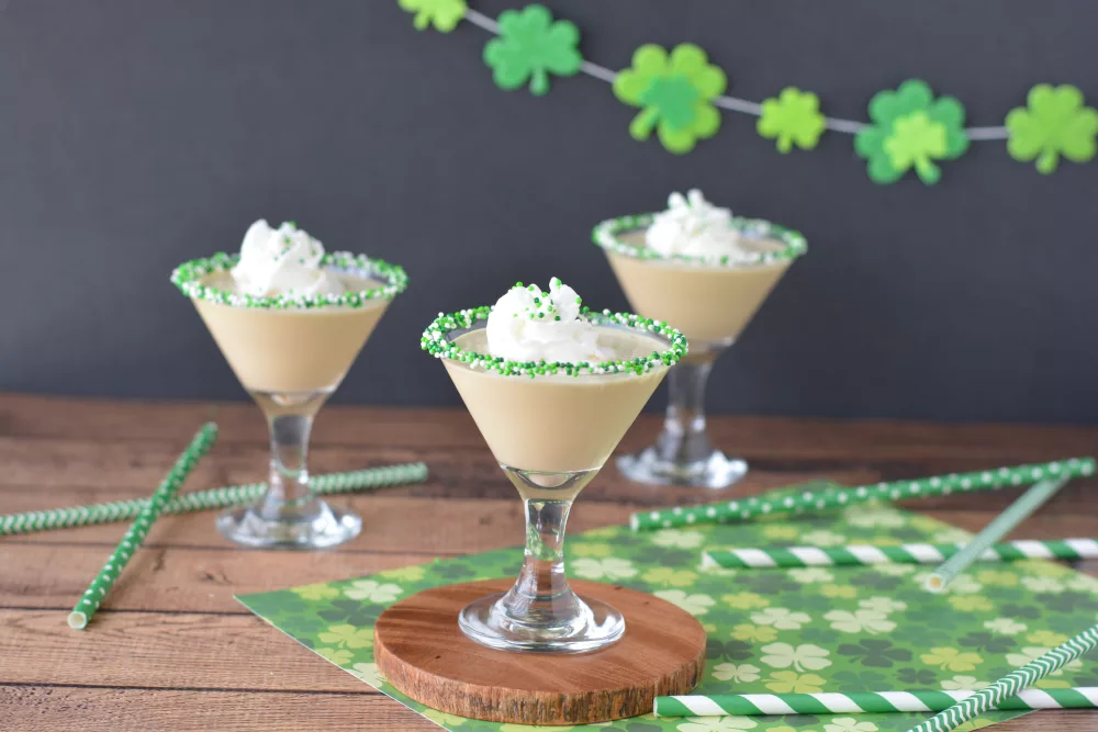 frozen coffee drinks in martini glasses decorated with whipped cream and green sprinkles