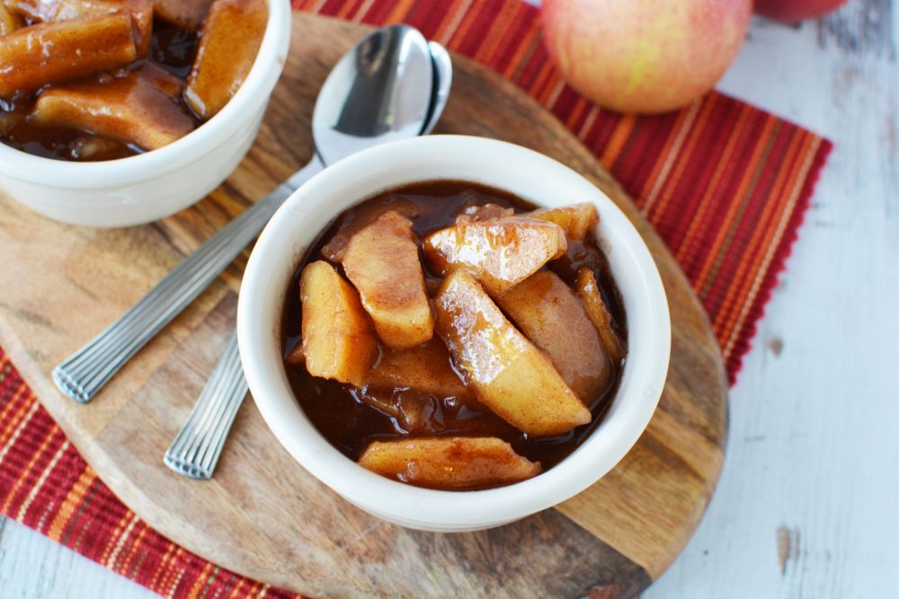 overhead sot of small bowl filled with chunks of apples and cinnamon sauce