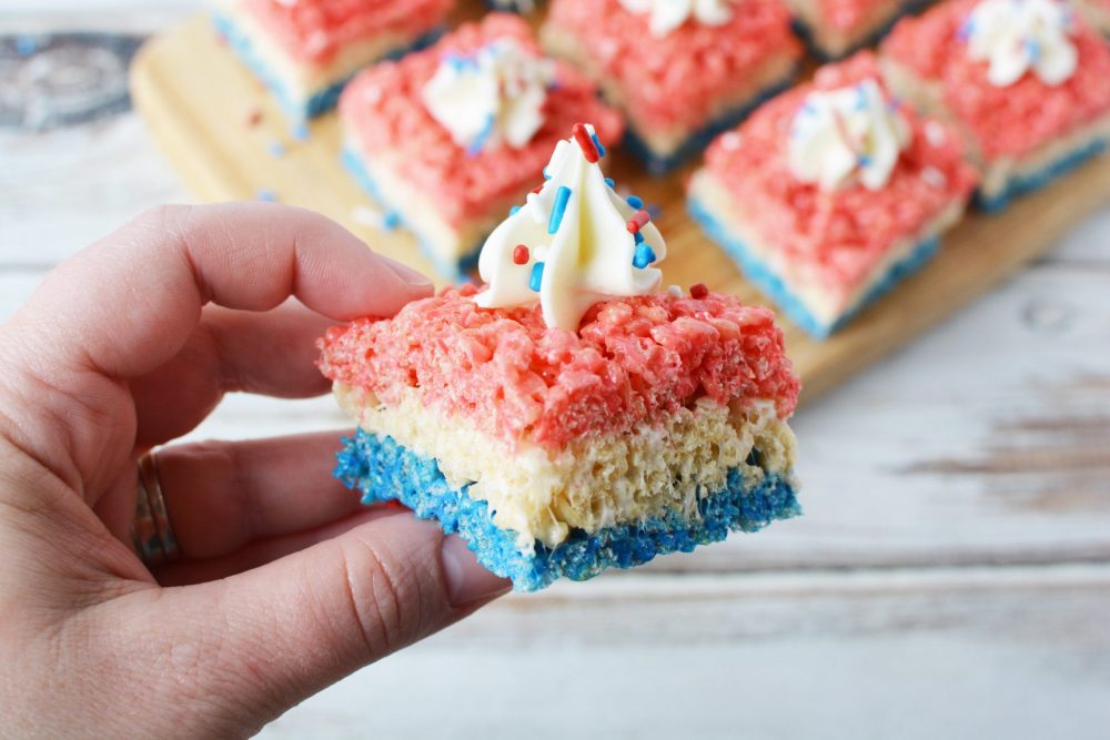 treated layered with red, white and blue coloring, and topped with whipped topping and sprinkles