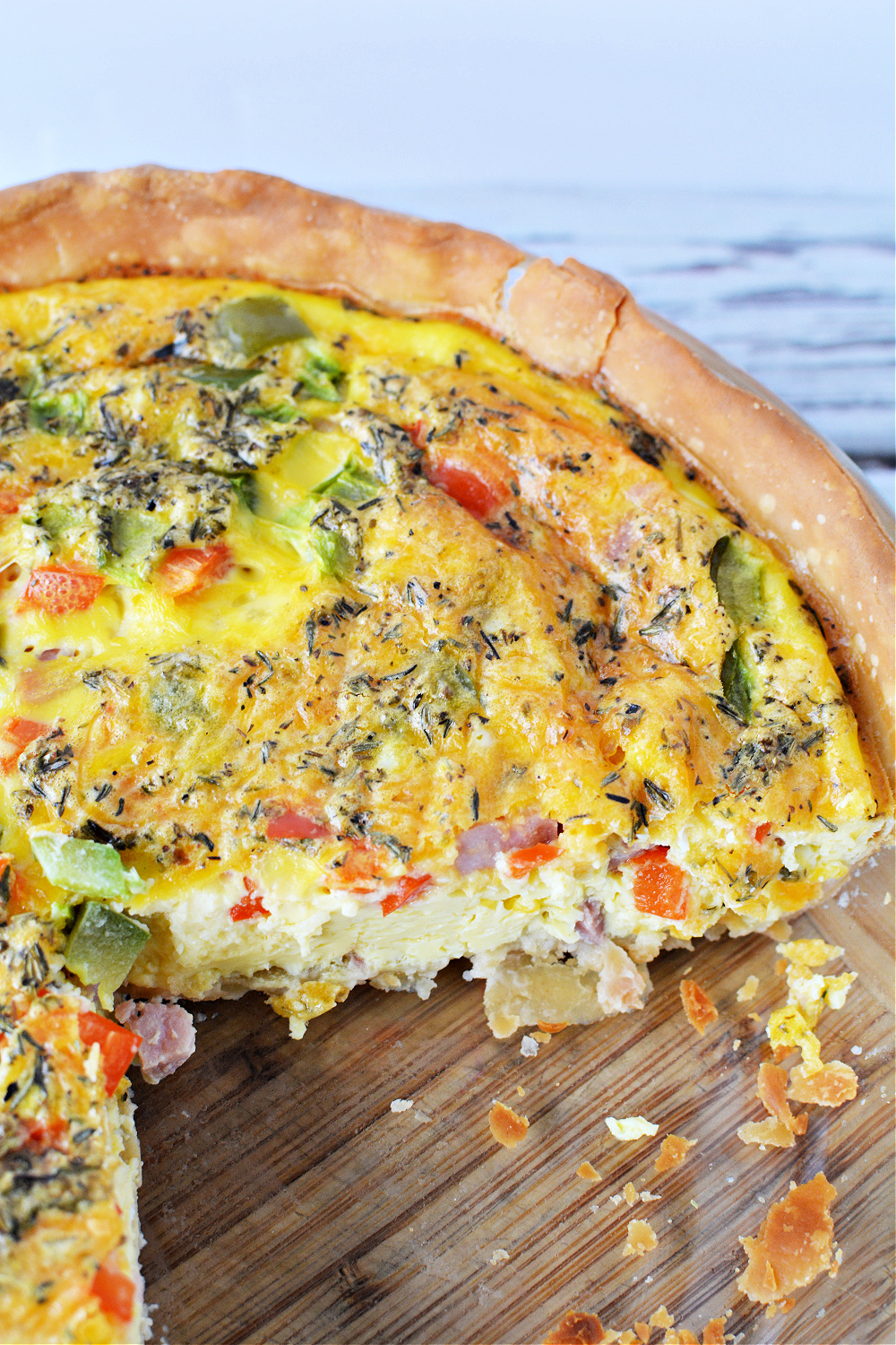 a breakfast pie filled with diced ham, red peppers, green peppers and lots of cheddar cheese