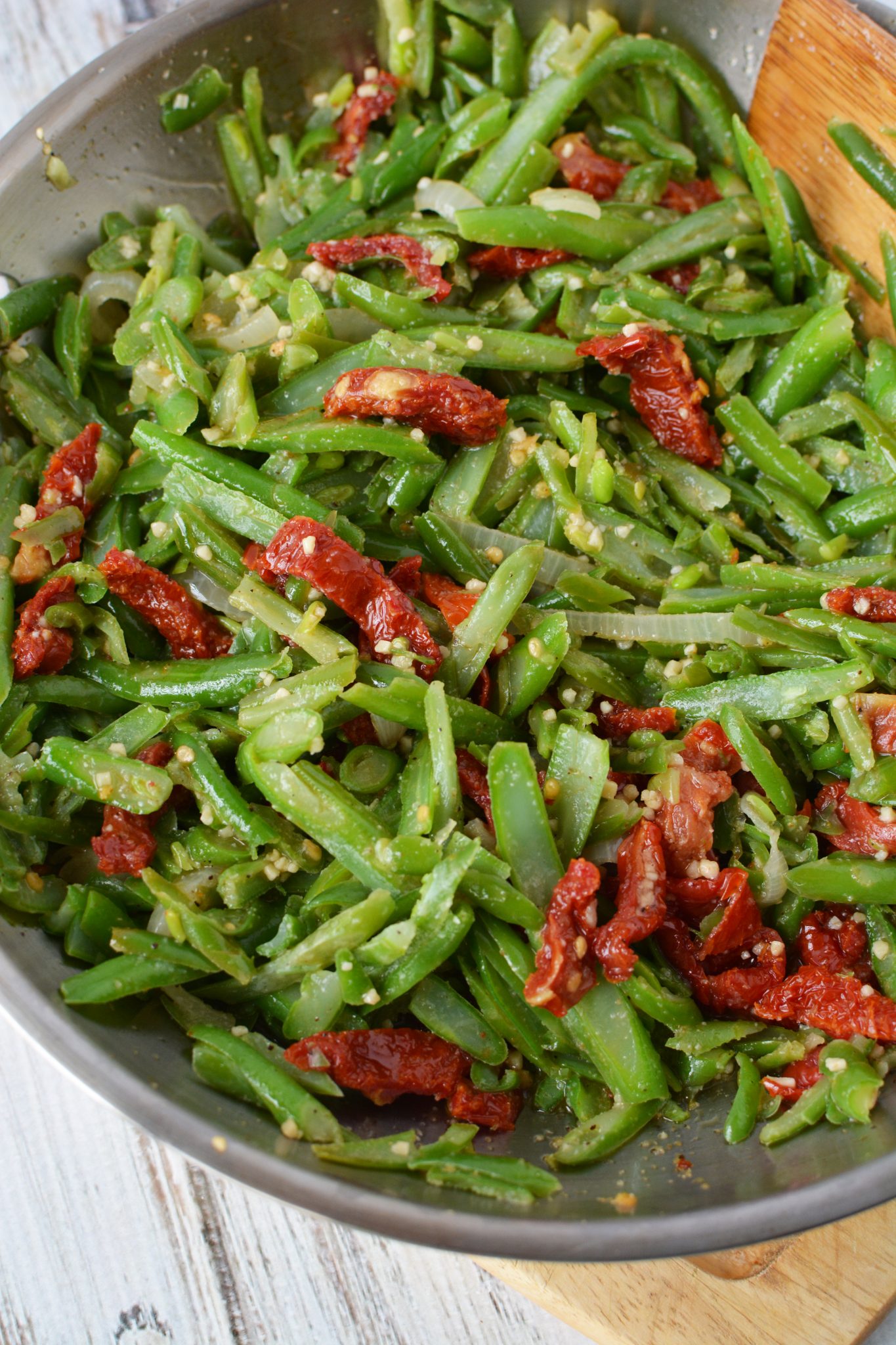 green beans, garlic, onions and tomatoes in a frying pan