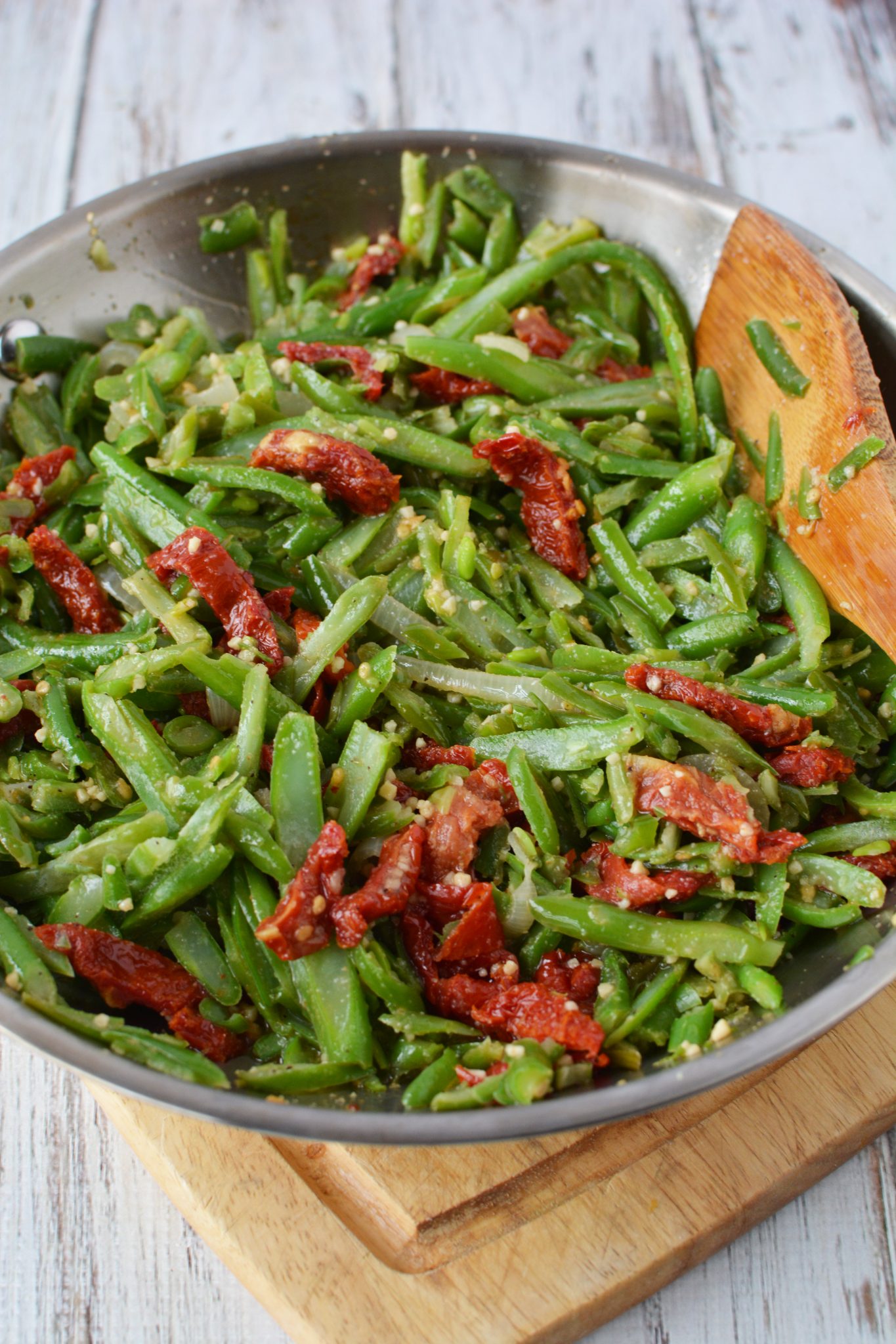 green beans, garlic, onions and tomatoes in a frying pan