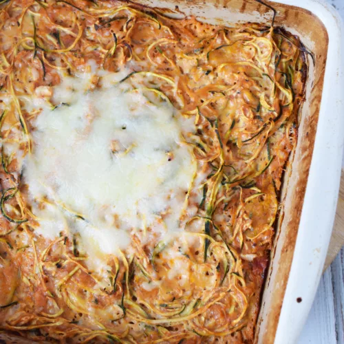 spiralized zucchini in a casserole with melted cheese on top