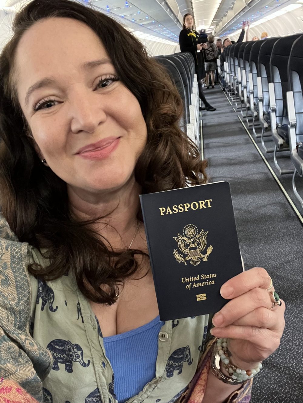 Jennifer holding a passport on a plane
