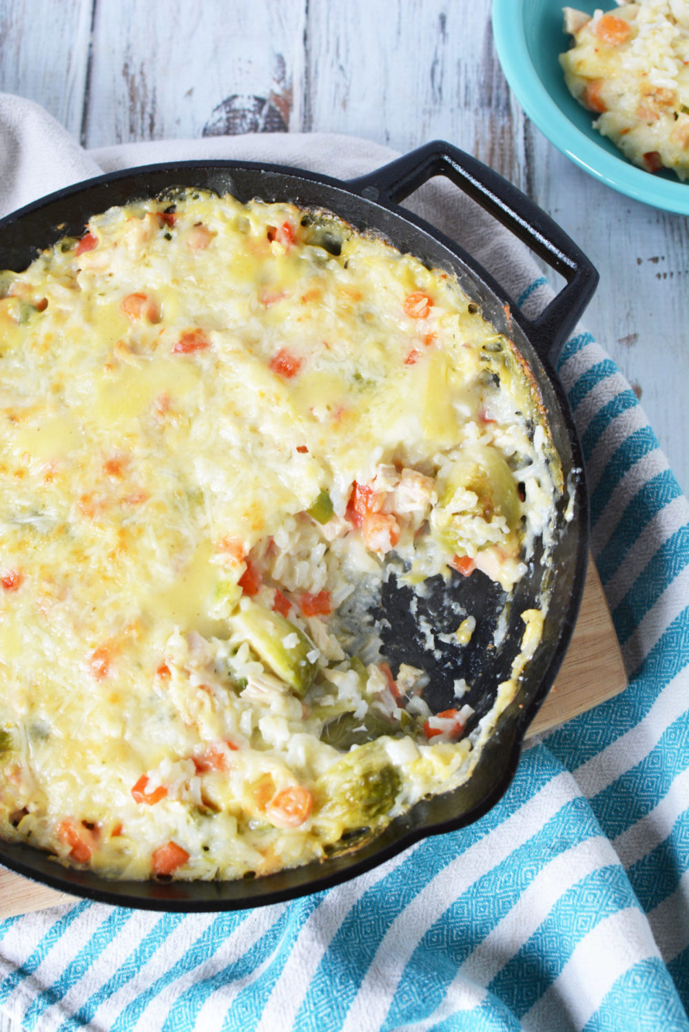 veggie casserole with chicken and cheese in a cast iron skillet