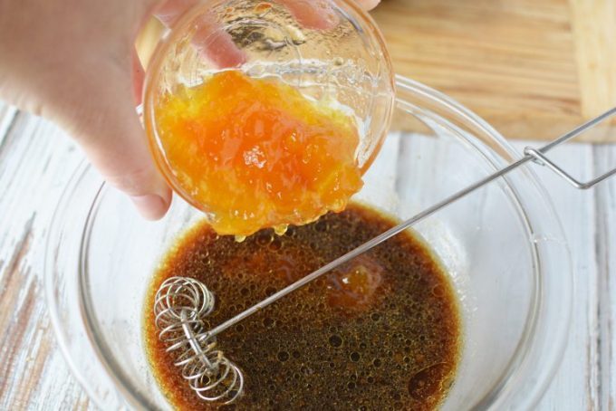 peach preserves being poured into a bowl