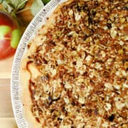 Oat Crumble Topped Apple Pie in a pie plate with apples next to it