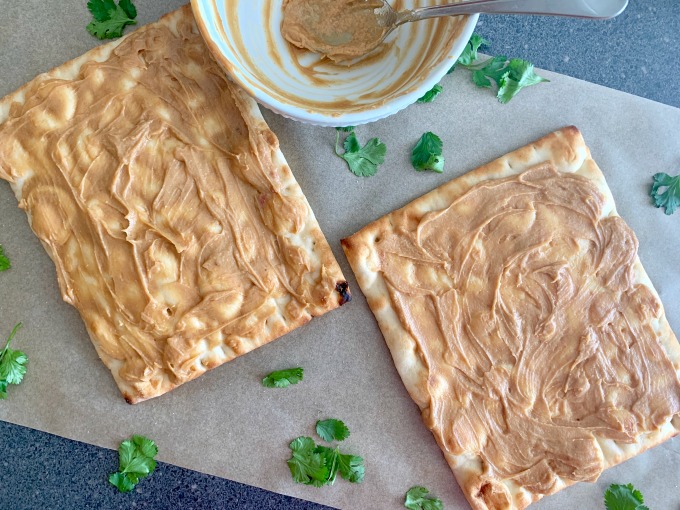 Spread peanut sauce over the flatbread in a thick layer.