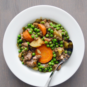 Veggie Beef Stew in a bowl filled with peas and carrots