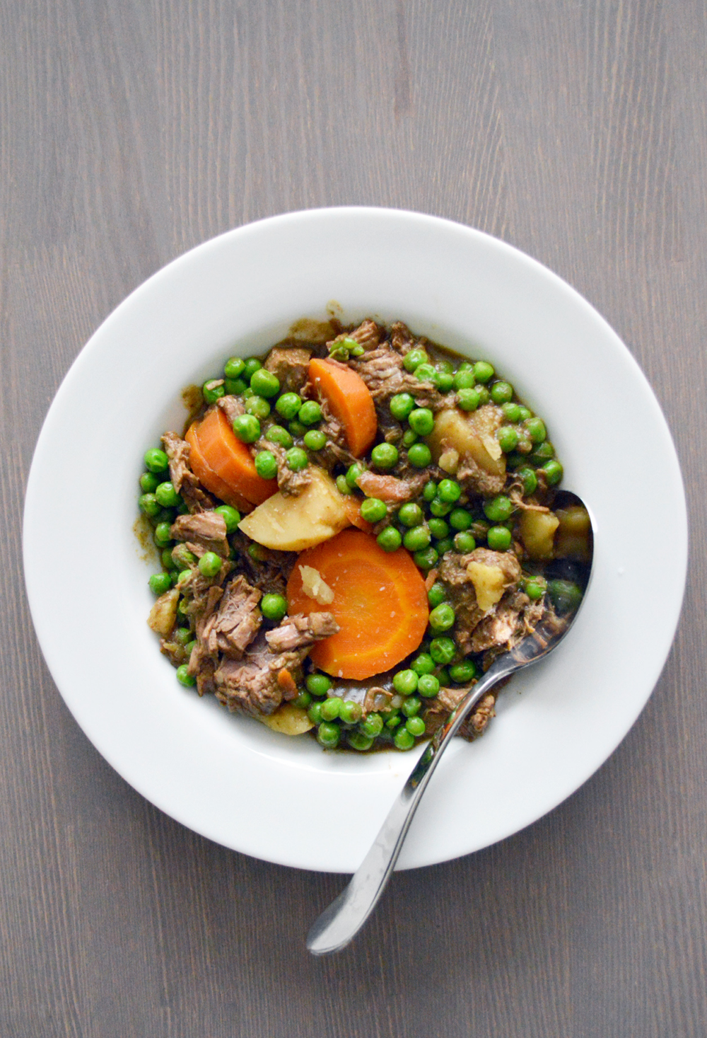 Veggie Beef Stew in a bowl filled with peas and carrots