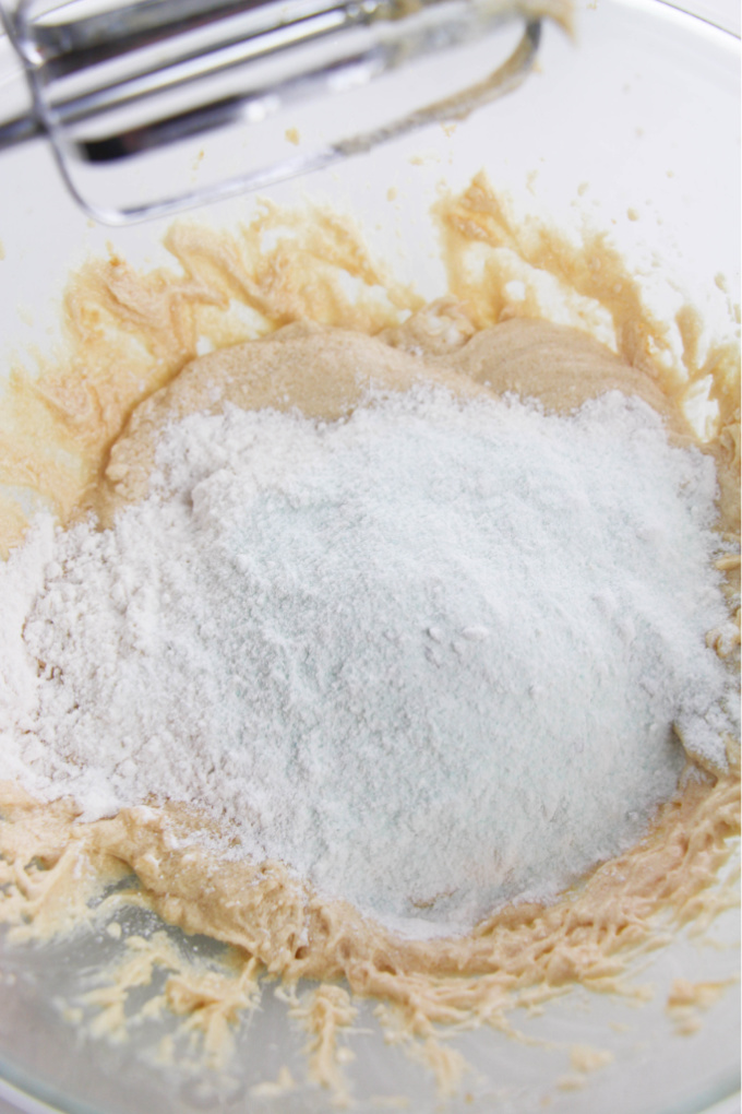 brown sugar and white sugar in a bowl with flour poured on top