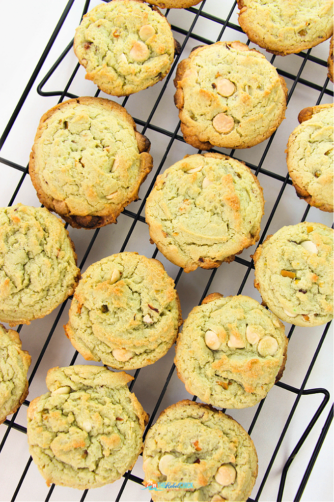 pistachio cookies with white chocolate chips on a wire cooling rack