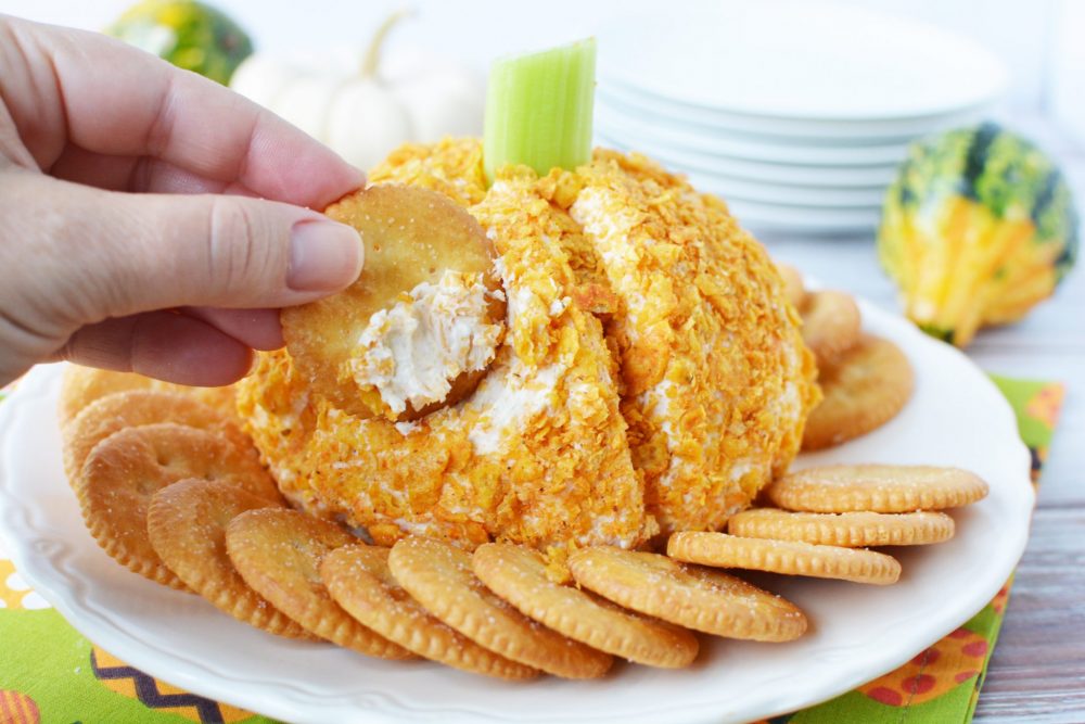 cheese ball covered in crushed doritos shaped like a pumpkin
