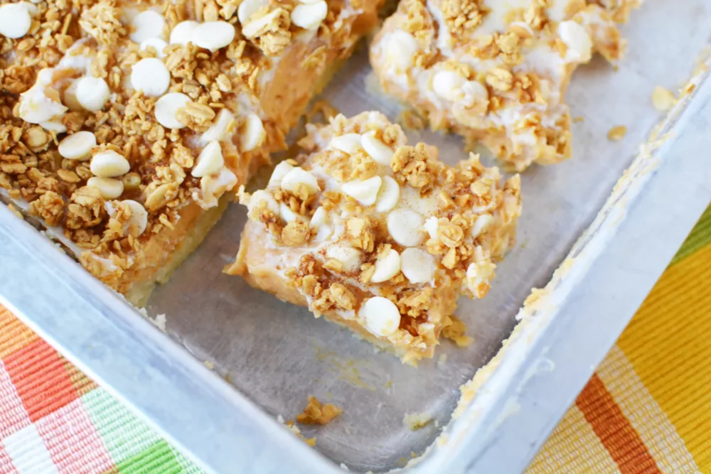 Sweet Potato Cheesecake Bars topped with crumbly topping in a baking pan