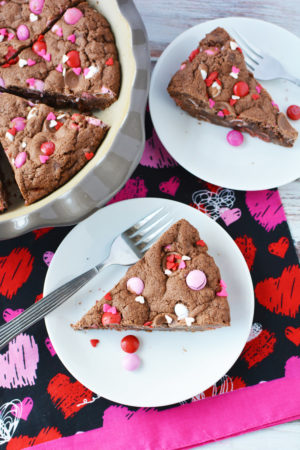 Ingredients to make this Valentine Double Chocolate Cookie Pie Recipe 1 pouch, 17.5 oz, double chocolate chunk cookie mix 1 stick, 1/2 cup, butter, softened 1 tablespoon water 1 egg 1 cup M&M candies 12 rolo candies Valentine sprinkles Directions to make this Valentine Double Chocolate Cookie Pie Recipe Preheat oven to 350 and grease a 9" pie pan. Set aside.  In a mixing bowl, combine cookie mix, butter, water and egg and mix well until dough forms. Dough will be stiff but come together with a good mix. Reserve 2 tablespoons of M&M candies. Fold in remaining candies until mixed well. Then pour your batter into prepared pan and spread evenly.  Top with rolo candies and remaining M&M candies. Bake for 35 minutes. Remove from oven and cool until just warm. Slice and serve. 