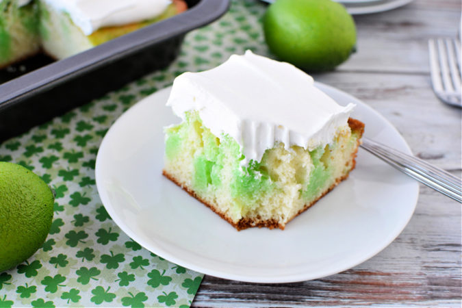 slice of white cake with green jello inside and smothered in cool whip topping