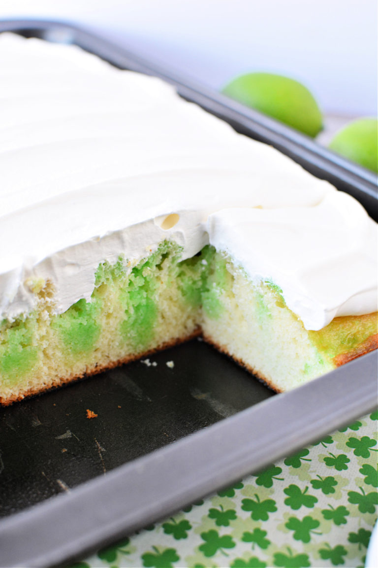 fluffy white cake with lime green jello throughout, covered in cool whip as frosting