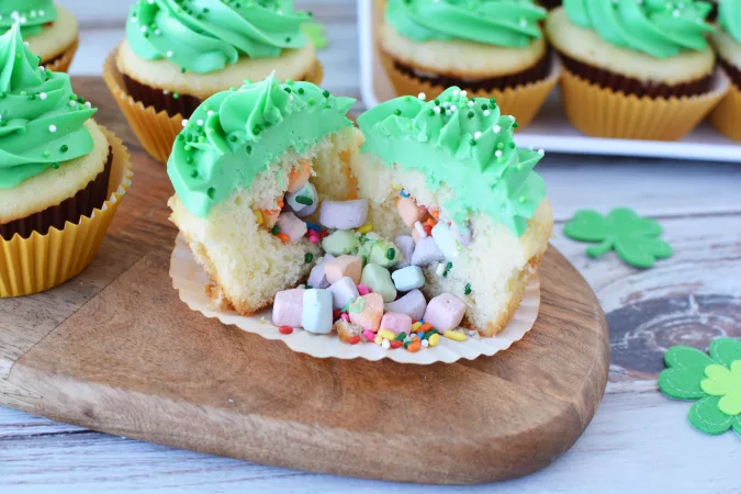 vanilla cupcake filled with lucky charms marshmalllows and covered with green frosting