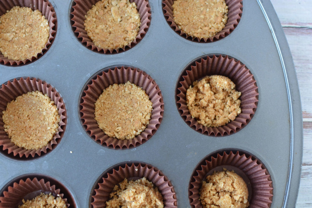 Filling a muffin tin with graham cracker crust 