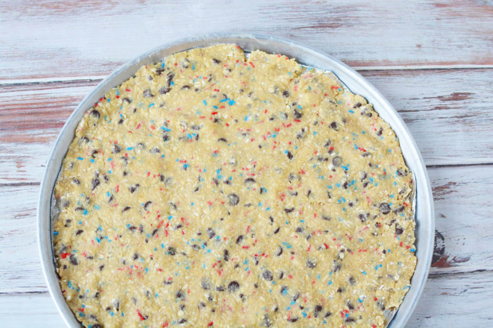 Unbaked chocolate chip cookie dough in a pie plate