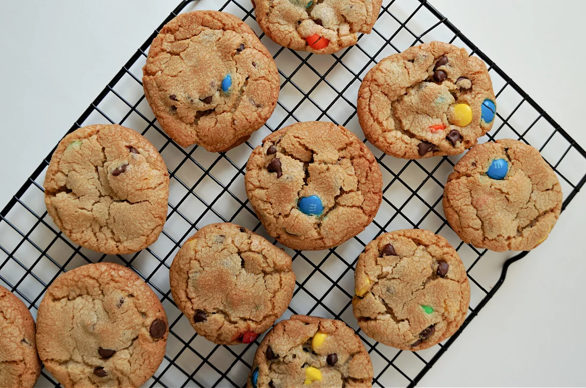 golden brown cookies with chocolate chips and M&Ms candies on a wire cooling rack